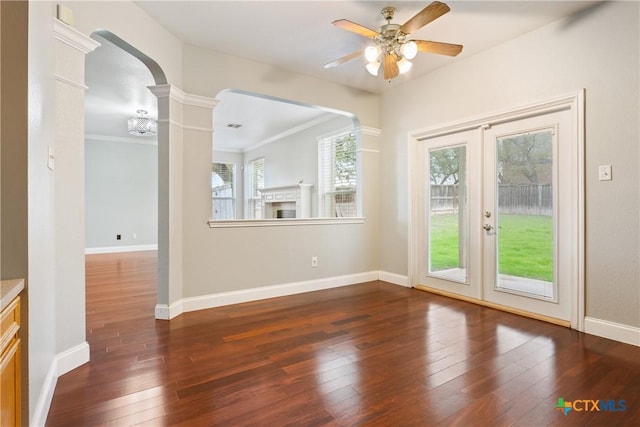 interior space with ornamental molding, ceiling fan, decorative columns, and dark hardwood / wood-style floors