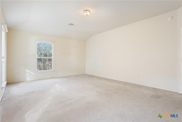 empty room with lofted ceiling and carpet flooring