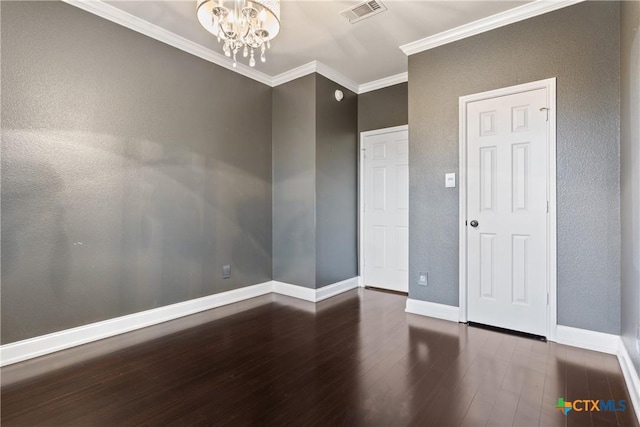 unfurnished room with dark hardwood / wood-style flooring, an inviting chandelier, and crown molding