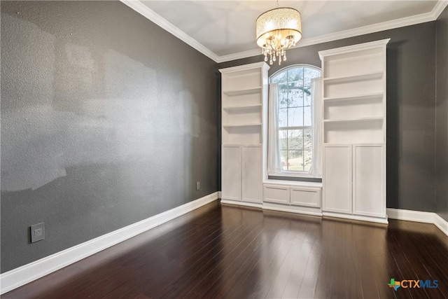 empty room with dark wood-type flooring, an inviting chandelier, and crown molding