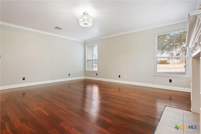 empty room featuring ornamental molding, dark hardwood / wood-style floors, an inviting chandelier, and plenty of natural light