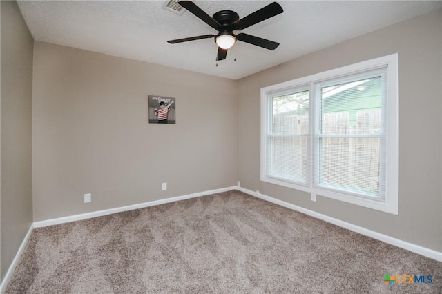 unfurnished room with carpet floors, ceiling fan, baseboards, and visible vents