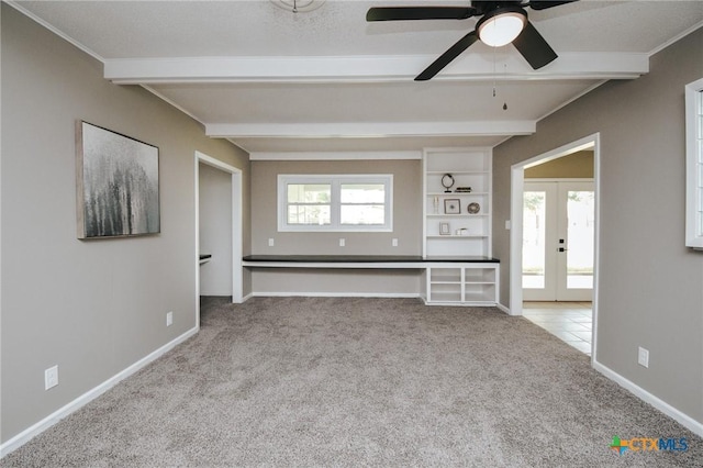 unfurnished living room featuring carpet floors, ceiling fan, french doors, and beam ceiling