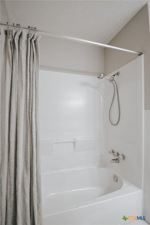 full bathroom with shower / bath combo and a textured ceiling