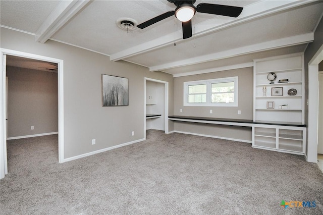 unfurnished living room featuring ceiling fan, a textured ceiling, beam ceiling, baseboards, and carpet