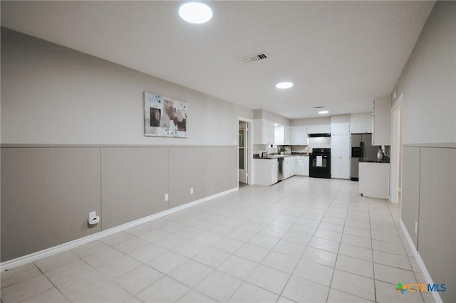 empty room with recessed lighting, visible vents, light tile patterned floors, and a wainscoted wall