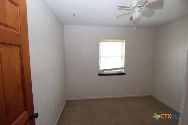 carpeted empty room with baseboards and ceiling fan