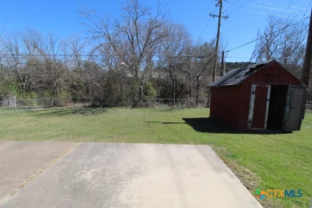 view of yard featuring an outbuilding, a storage unit, and fence private yard