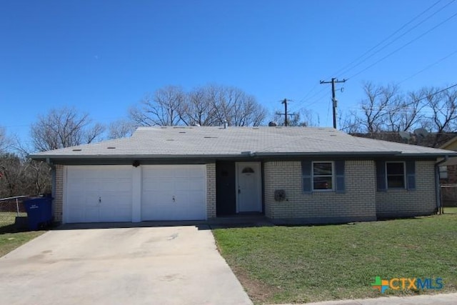 single story home with a front yard, an attached garage, brick siding, and concrete driveway