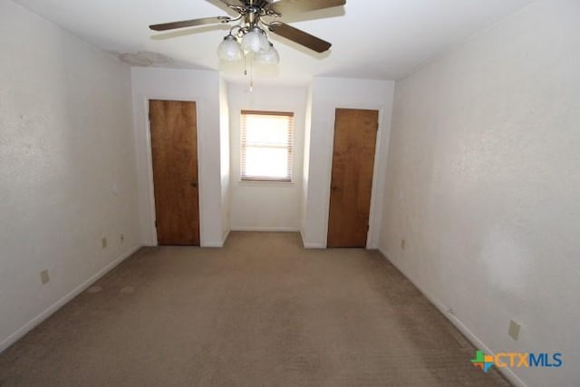 unfurnished room featuring baseboards, light carpet, and ceiling fan