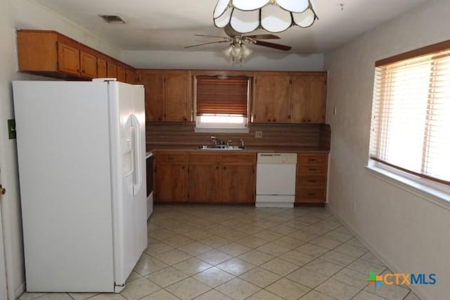 kitchen featuring visible vents, plenty of natural light, white appliances, and a sink