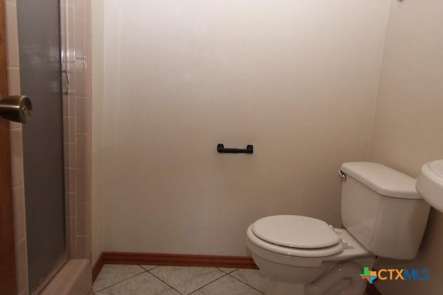 full bath with tile patterned floors, toilet, baseboards, and a stall shower