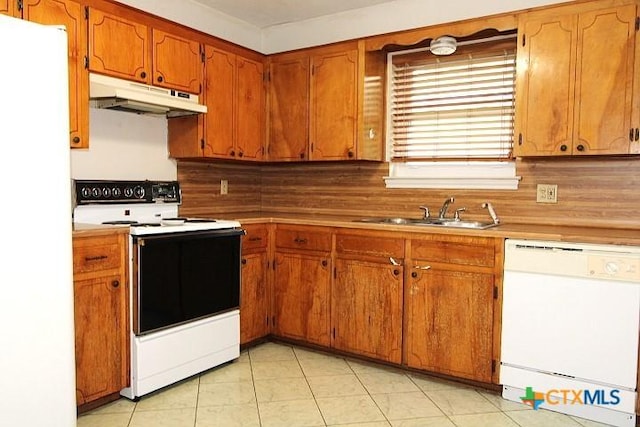 1306 Dryden Ave, Copperas Cove, TX 76522 - kitchen with white appliances, under cabinet range hood, brown cabinetry, and light countertops