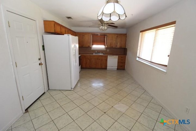 kitchen with visible vents, white appliances, brown cabinetry, light tile patterned floors, and ceiling fan