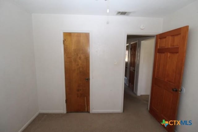 unfurnished room featuring visible vents, baseboards, and light colored carpet