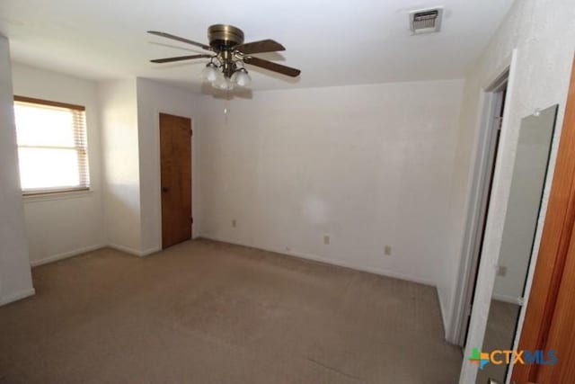 unfurnished bedroom featuring visible vents, light carpet, and ceiling fan