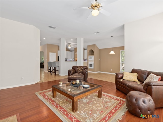 living room with lofted ceiling, wood-type flooring, and ceiling fan