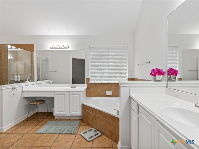 bathroom with independent shower and bath, vanity, lofted ceiling, and tile patterned floors