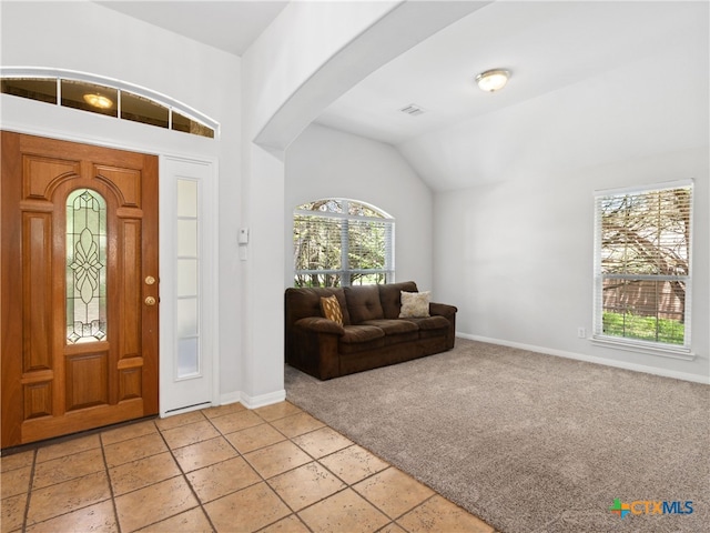 entryway with lofted ceiling and light colored carpet