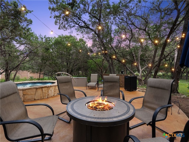 patio terrace at dusk featuring a fire pit