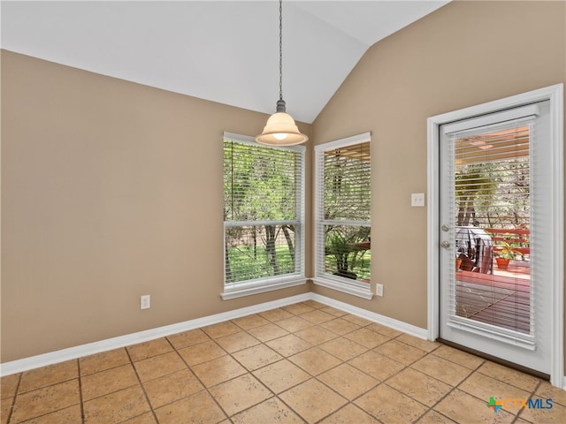 unfurnished dining area featuring lofted ceiling and tile patterned floors