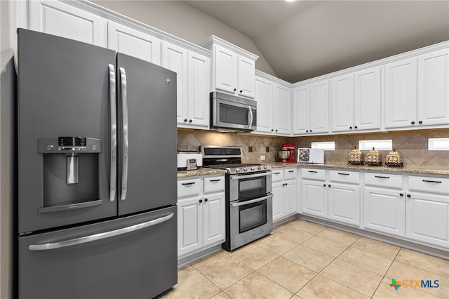 2935 Angelina Dr, Round Rock, TX 78665 - kitchen with appliances with stainless steel finishes, lofted ceiling, decorative backsplash, light tile patterned floors, and white cabinetry