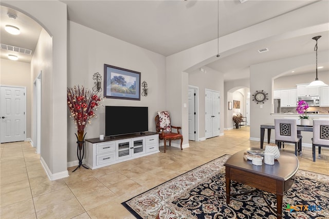 2935 Angelina Dr, Round Rock, TX 78665 - living area featuring arched walkways, light tile patterned flooring, and baseboards