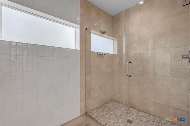 bathroom featuring wood-type flooring and a shower with door