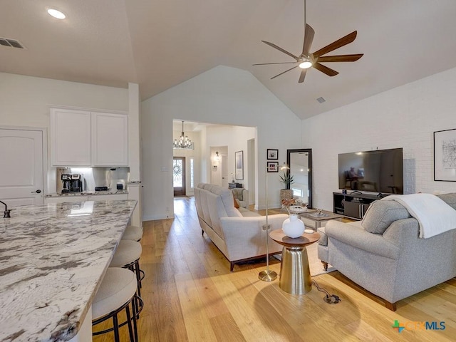599 Mission Hill Run, New Braunfels, TX 78132 - living area with a ceiling fan, light wood-style floors, high vaulted ceiling, and a chandelier