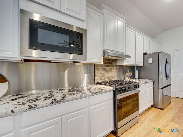 599 Mission Hill Run, New Braunfels, TX 78132 - kitchen with appliances with stainless steel finishes, under cabinet range hood, white cabinets, light wood finished floors, and decorative backsplash