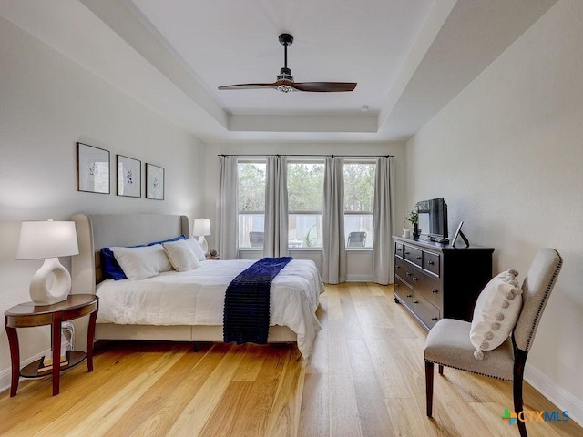 599 Mission Hill Run, New Braunfels, TX 78132 - bedroom with a raised ceiling, light wood finished floors, a ceiling fan, and baseboards