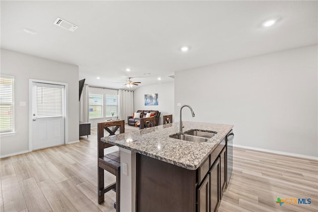 8903 Cantera Ridge Rd, Temple, TX 76502 - kitchen with dark brown cabinetry, light wood finished floors, a kitchen island with sink, recessed lighting, and a breakfast bar
