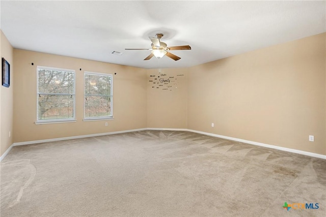 spare room with ceiling fan and light colored carpet