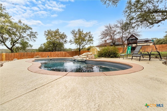 view of pool featuring a storage unit and a patio