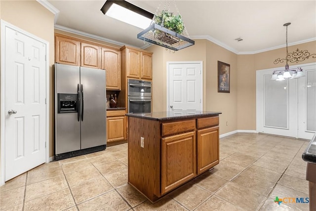 kitchen with appliances with stainless steel finishes, an inviting chandelier, a kitchen island, and ornamental molding