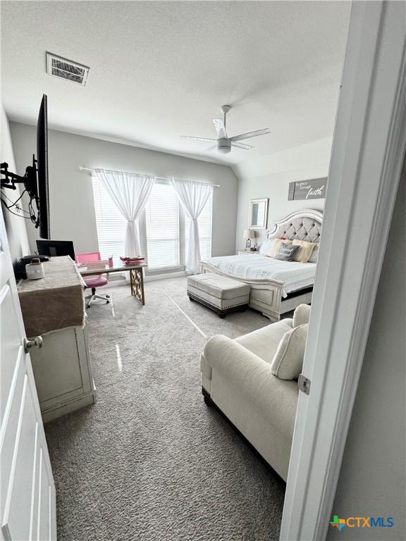 bedroom with a ceiling fan, visible vents, a textured ceiling, and carpet flooring