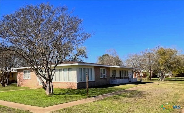 view of side of home with a yard and a carport