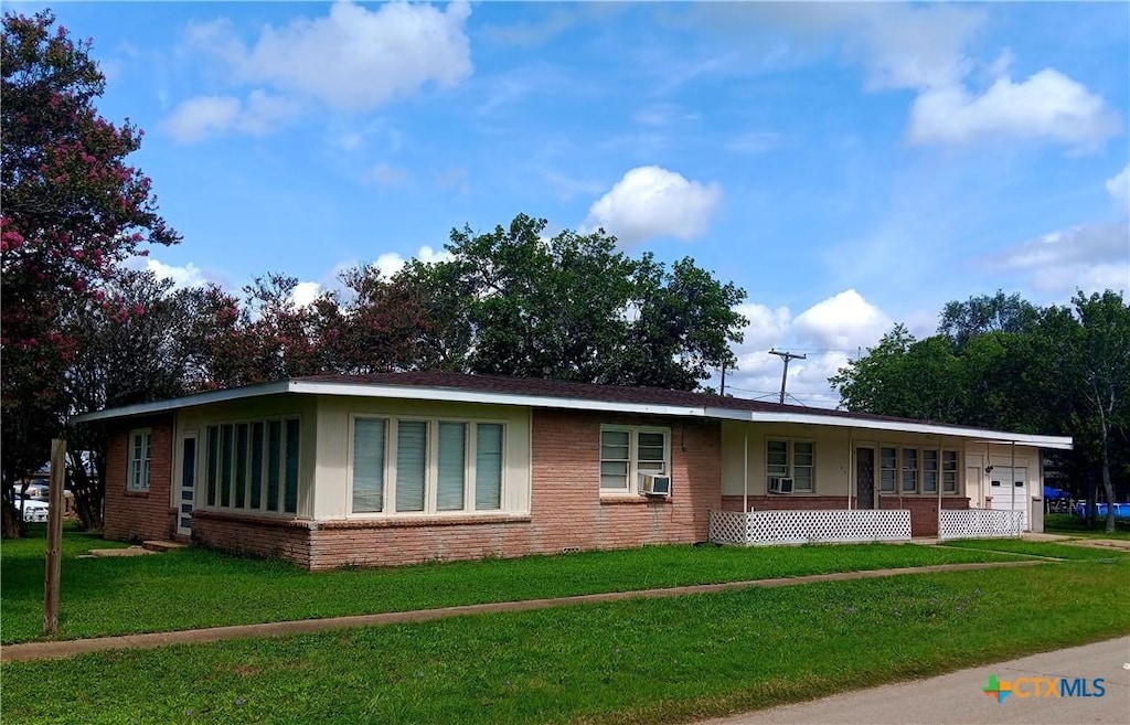 500 N Texas Ave, Nixon, TX 78140 - ranch-style house featuring brick siding, a front yard, a garage, and covered porch