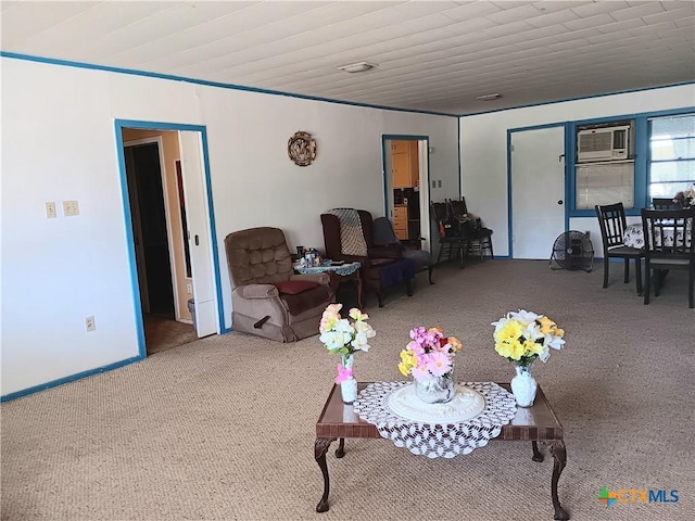 living room featuring a wall mounted air conditioner, carpet flooring, and crown molding