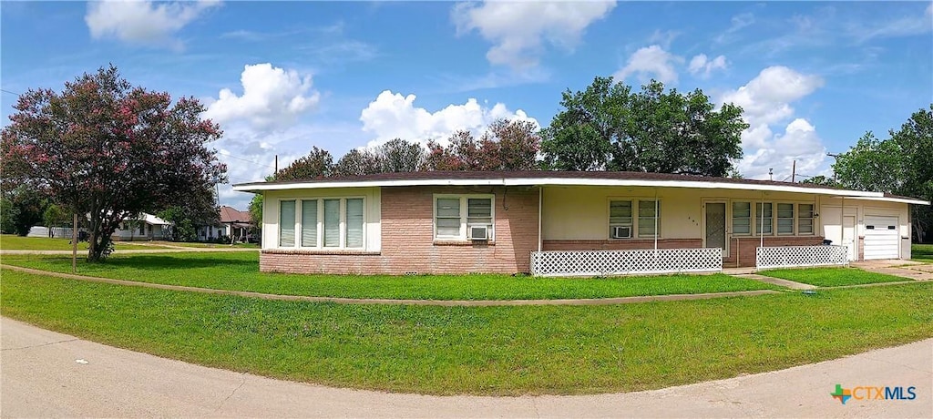 500 N Texas Ave, Nixon, TX 78140 - ranch-style home featuring a garage, a front lawn, a porch, brick siding, and cooling unit