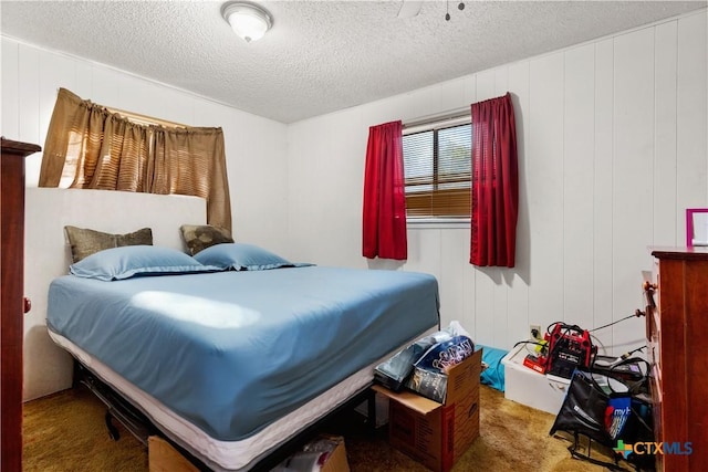 carpeted bedroom featuring wood walls and a textured ceiling