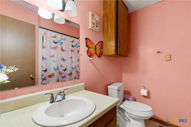 bathroom with vanity, toilet, and walk in shower