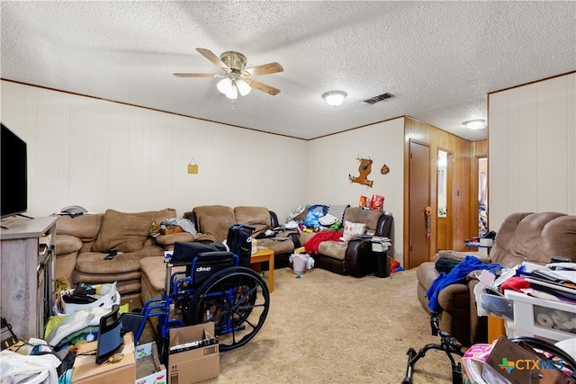 playroom featuring carpet flooring, ceiling fan, wood walls, and a textured ceiling