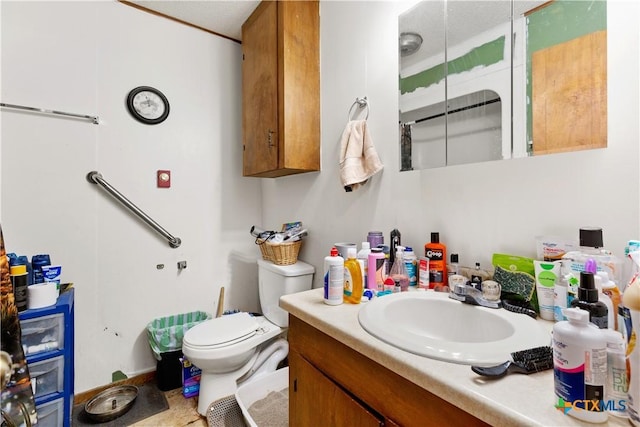 bathroom with a textured ceiling, vanity, and toilet