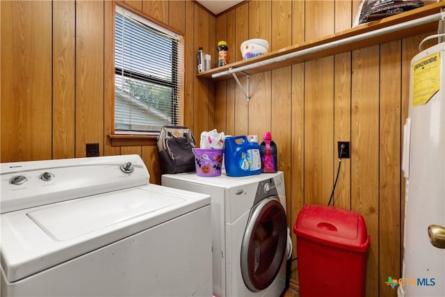 laundry room featuring gas water heater, independent washer and dryer, and wooden walls