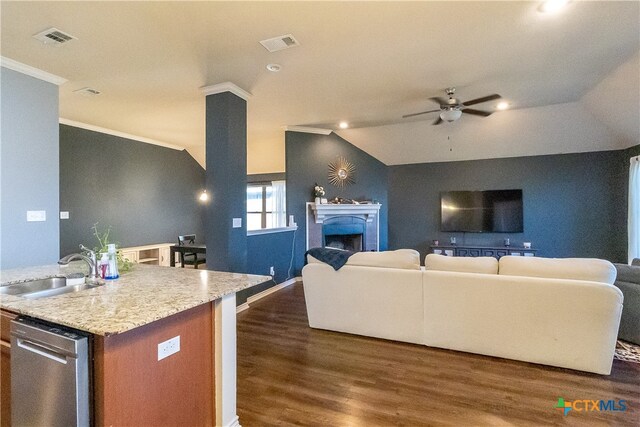 kitchen featuring a kitchen island with sink, sink, vaulted ceiling, stainless steel dishwasher, and ornamental molding