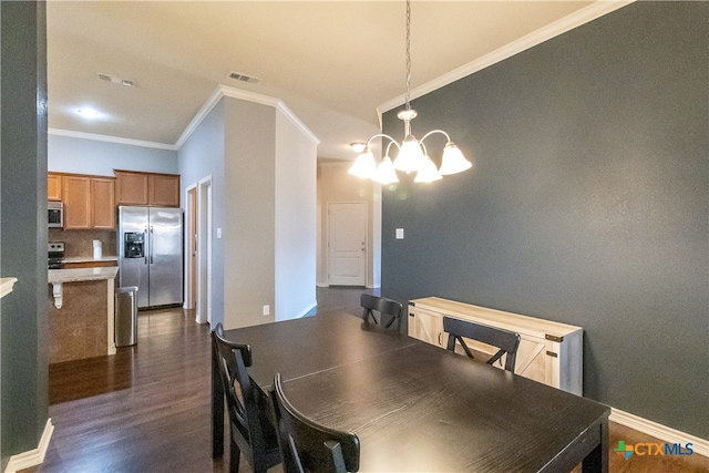 dining space featuring dark hardwood / wood-style floors, crown molding, and a chandelier