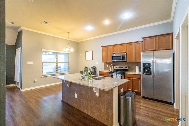 2529 Nolan Creek St, Temple, TX 76504 - kitchen with stainless steel appliances, dark wood-style floors, an island with sink, brown cabinets, and crown molding