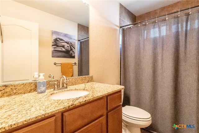 bathroom featuring vanity, curtained shower, and toilet