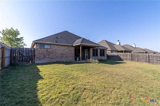 rear view of house featuring a yard